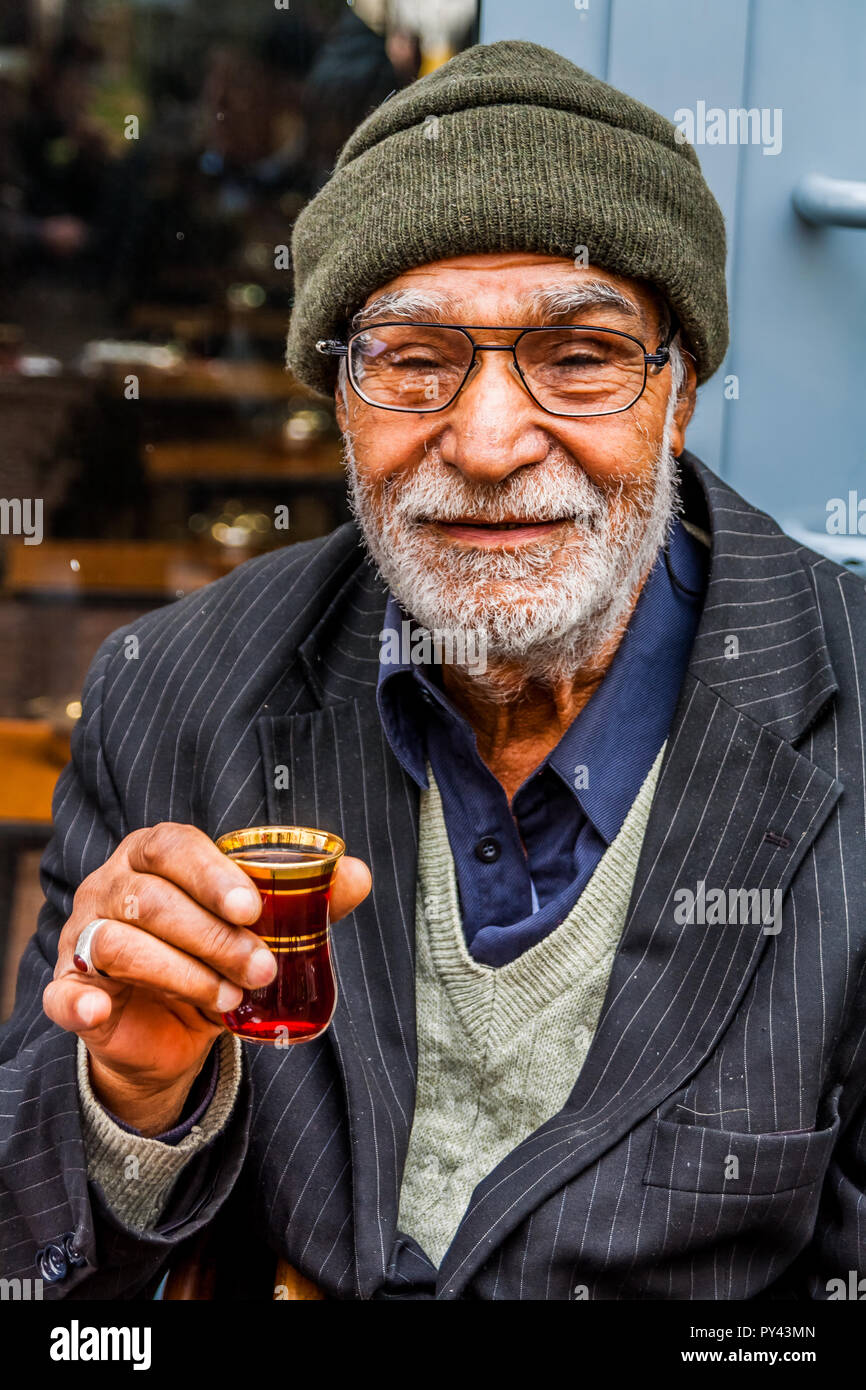 Istanbul, Turkey, December 6, 2011: elderly Turkish man drinking tea from a tea glass. Stock Photo