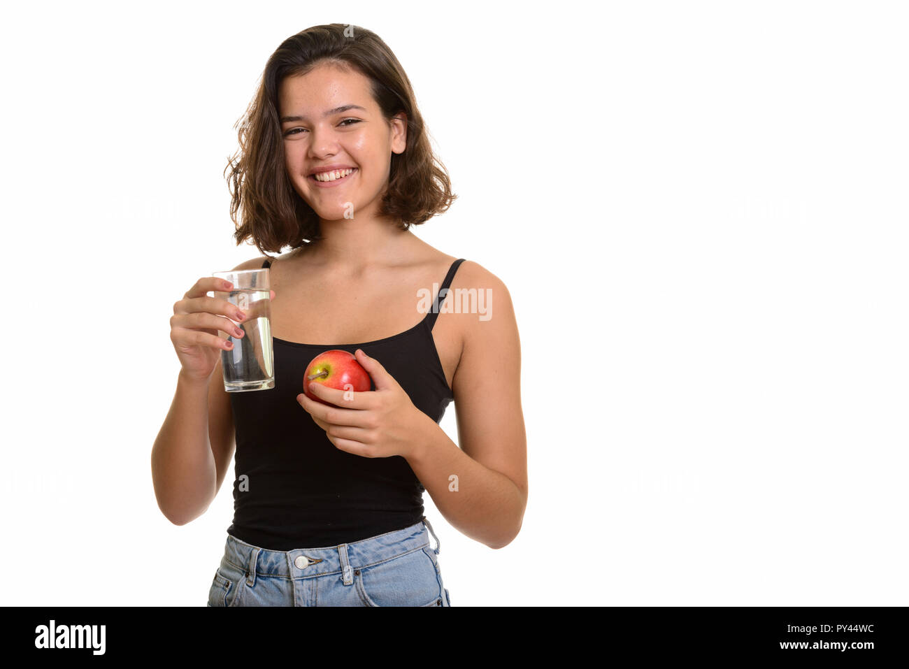 Young happy Caucasian teenage girl smiling while holding glass o Stock Photo