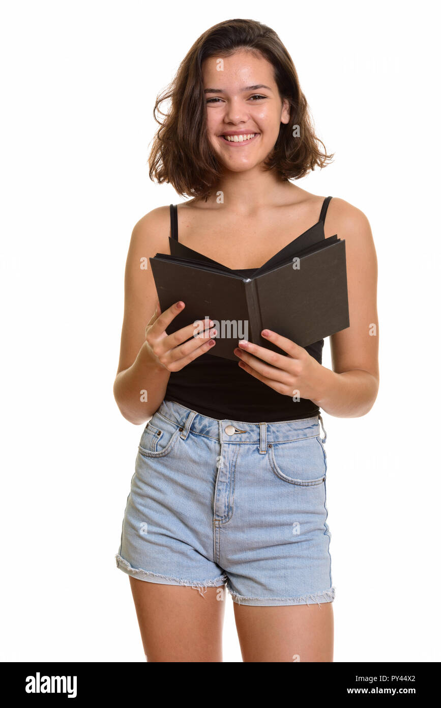 Young happy Caucasian teenage girl smiling while holding book Stock Photo
