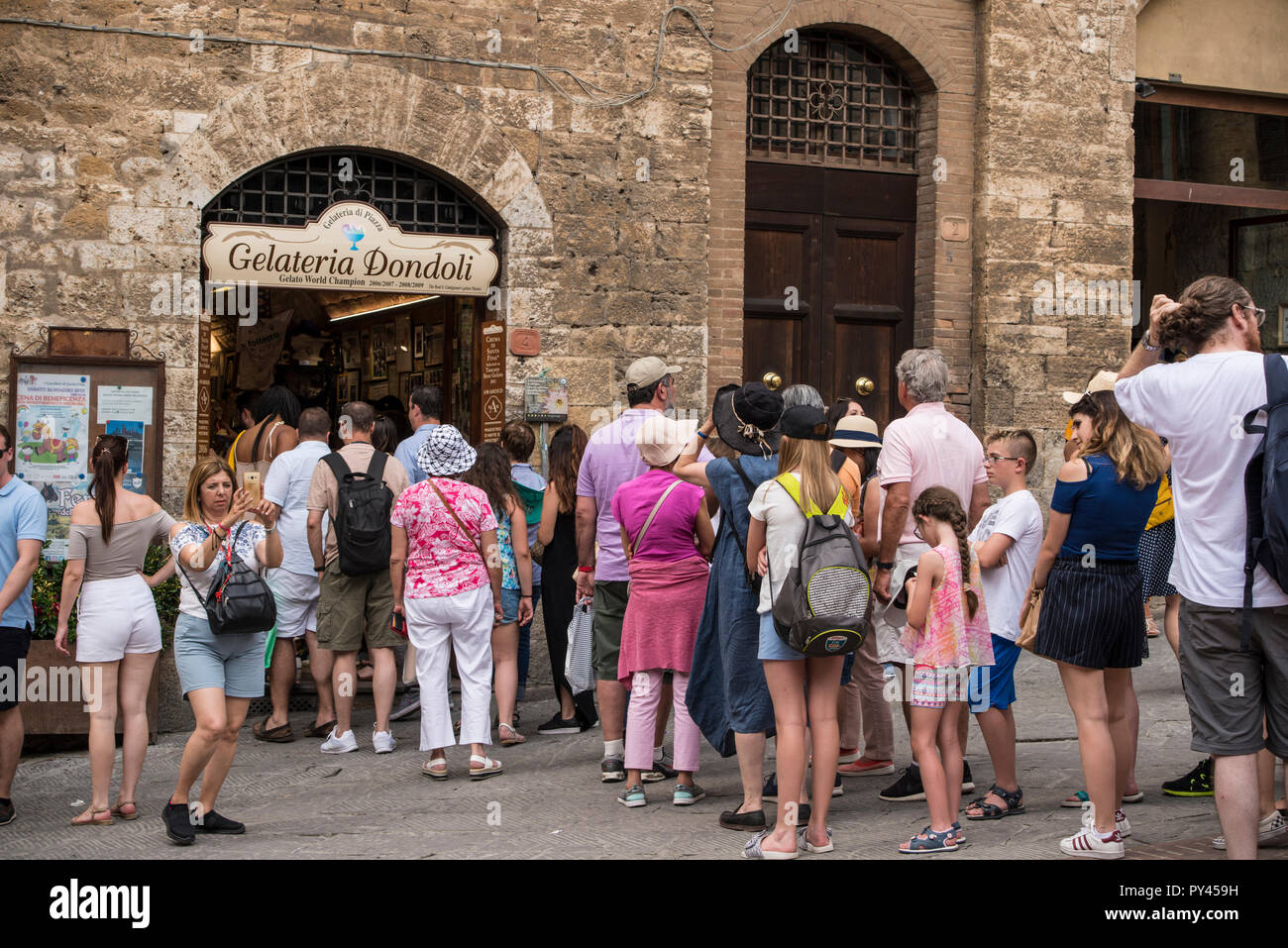 A very long queue for icecream outside of Gelateria Dondoli in hilltop town of San Gimignano, Tuscany, Italy Stock Photo