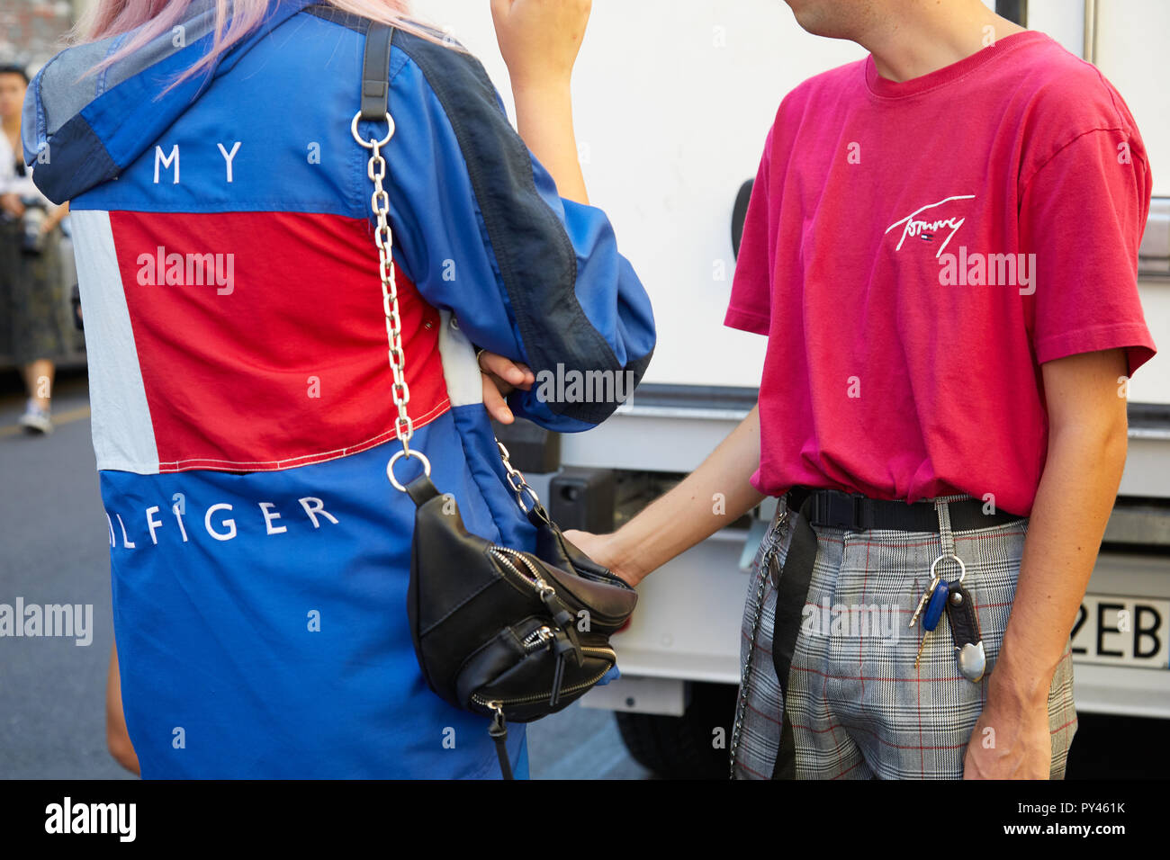 MILAN, ITALY - SEPTEMBER 23, 2018: Woman with blue, red and white Tommy Hilfiger jacket and man with pink shirt before Fila fashion show, Milan Fashio Stock Photo