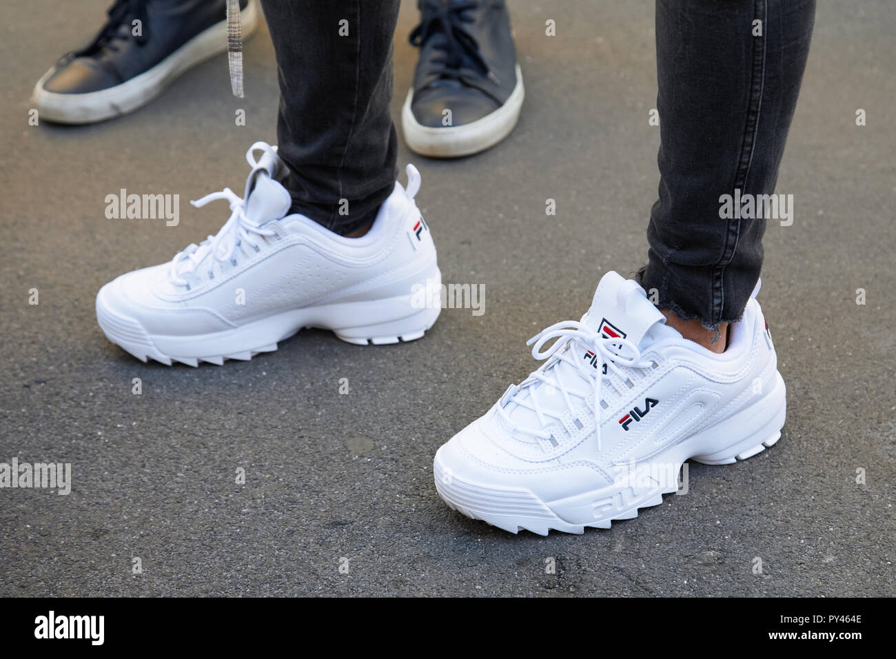 MILAN, ITALY - SEPTEMBER 23, 2018: Woman with white Fila sneakers and black  trousers before Fila fashion show, Milan Fashion Week street style Stock  Photo - Alamy