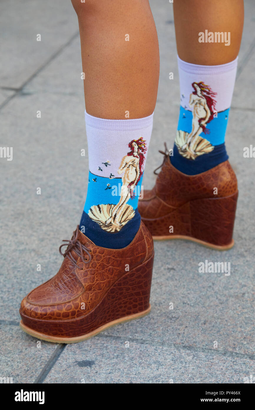MILAN, ITALY - SEPTEMBER 23, 2018: Woman with brown reptile leather wedge heel shoes with Botticelli Venus socks before Ujoh fashion show, Milan Fashi Stock Photo