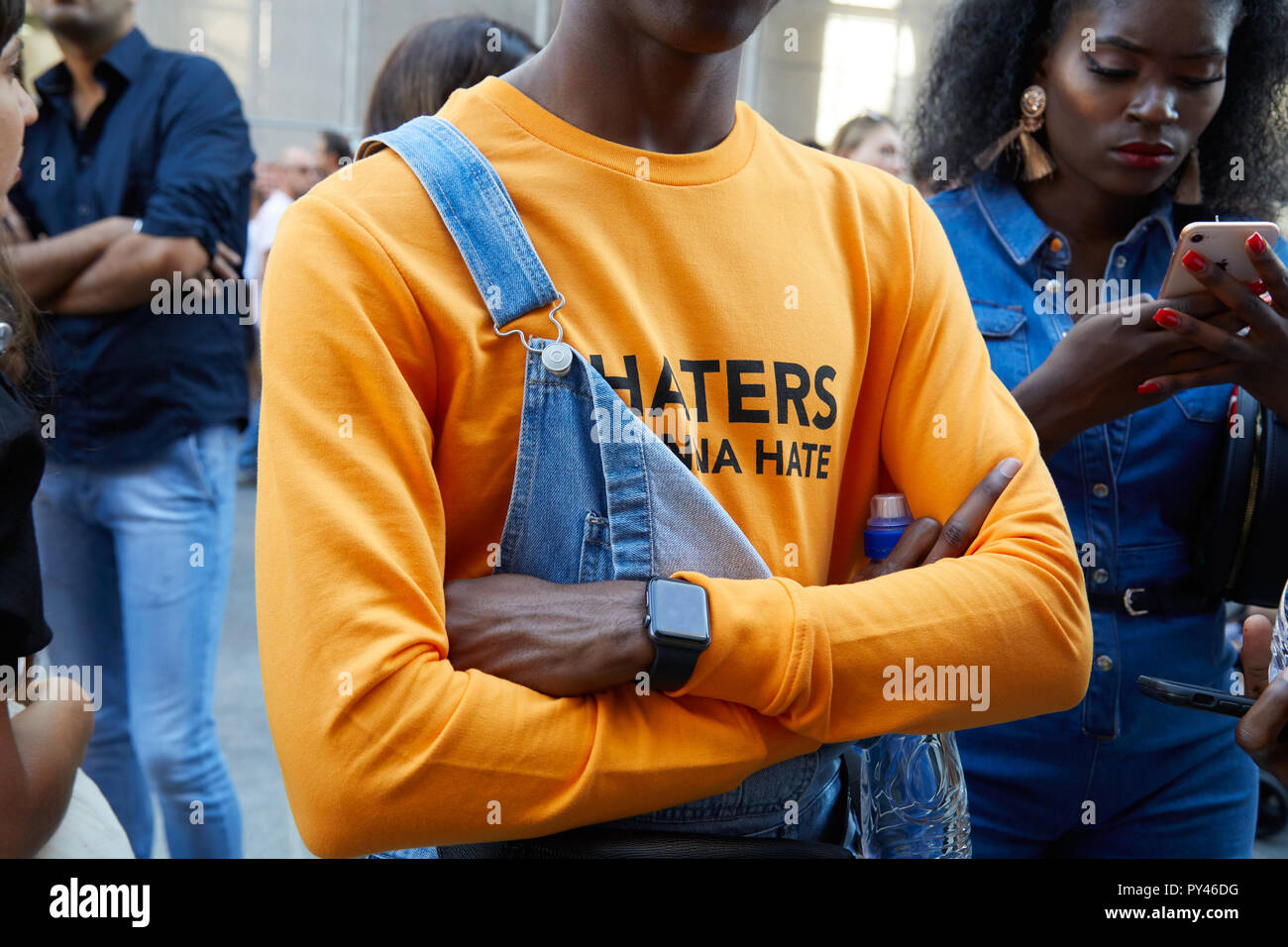 MILAN, ITALY - SEPTEMBER 23, 2018: Man with blue denim overalls and orange shirt before Cristiano Burani fashion show, Milan Fashion Week street style Stock Photo