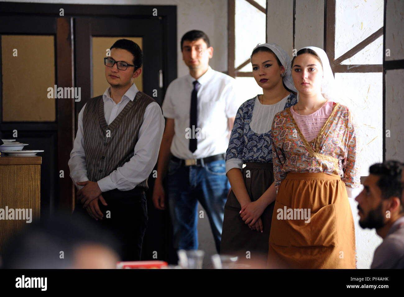At the Tatar restaurant: waitresses and waiter in Tatar native dress standing by counter while people eating at tables. September 8,2018. Kiev,Ukraine Stock Photo