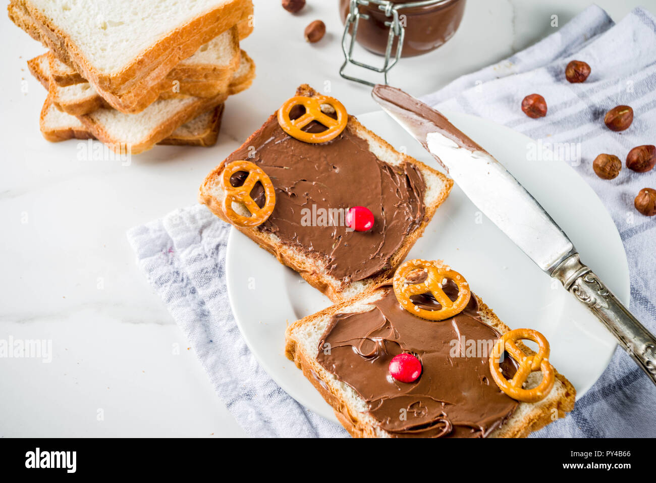 Chocolate and hazelnut spread sandwiches with white toasted bread, white marble background copy