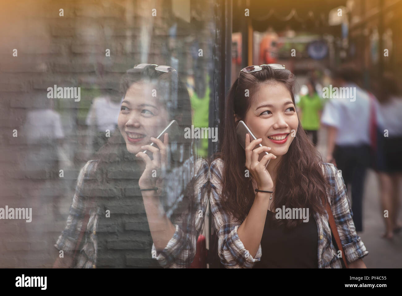 asian yonger woman toothy smiling face talking on mobile phone happiness emotion Stock Photo