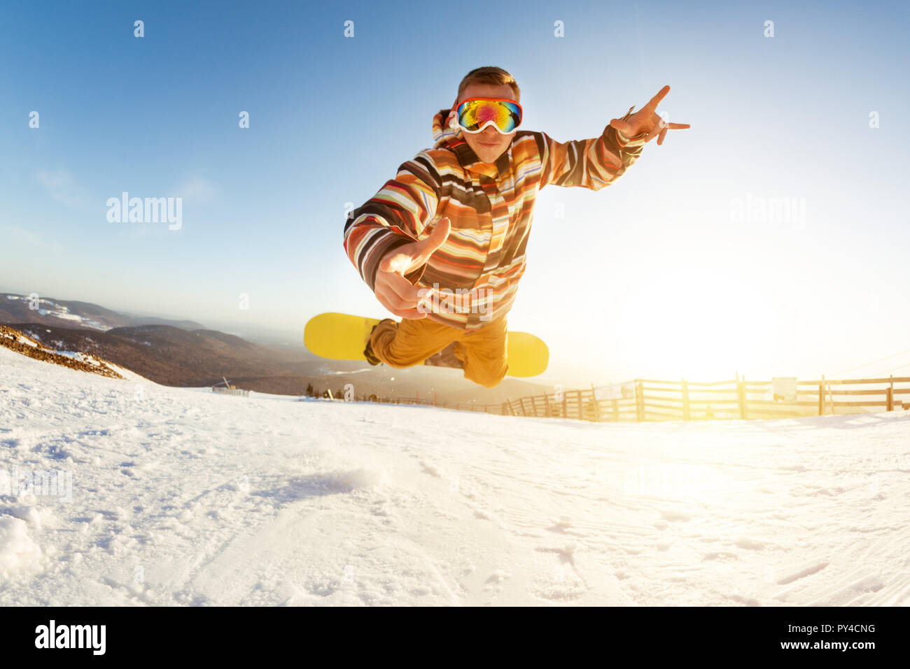 Snowboarder is having fun jumps and drop at ski slope at playful pose Stock Photo