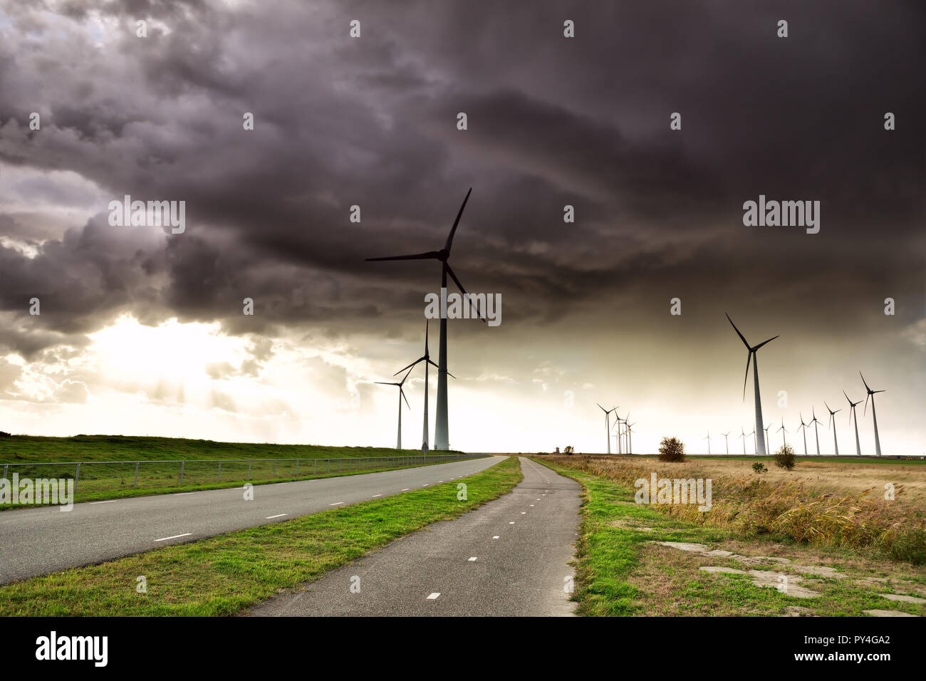 dark stormy sky over road and wind turbines, Holland Stock Photo - Alamy