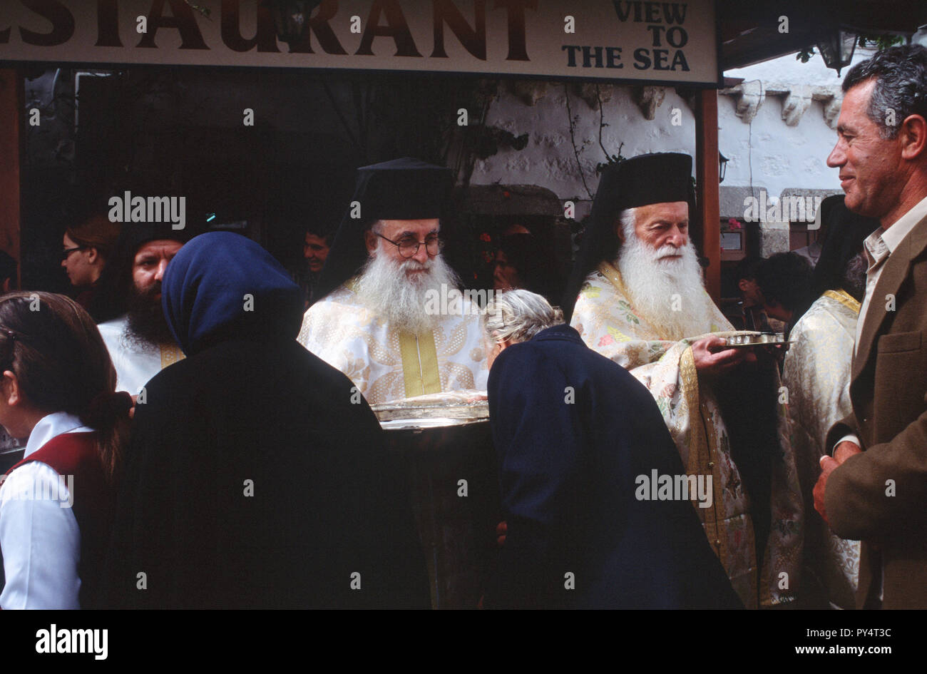 People kiss sacred relics held by monks during Holy Week celebrations on the Greek island of Patmos. Stock Photo