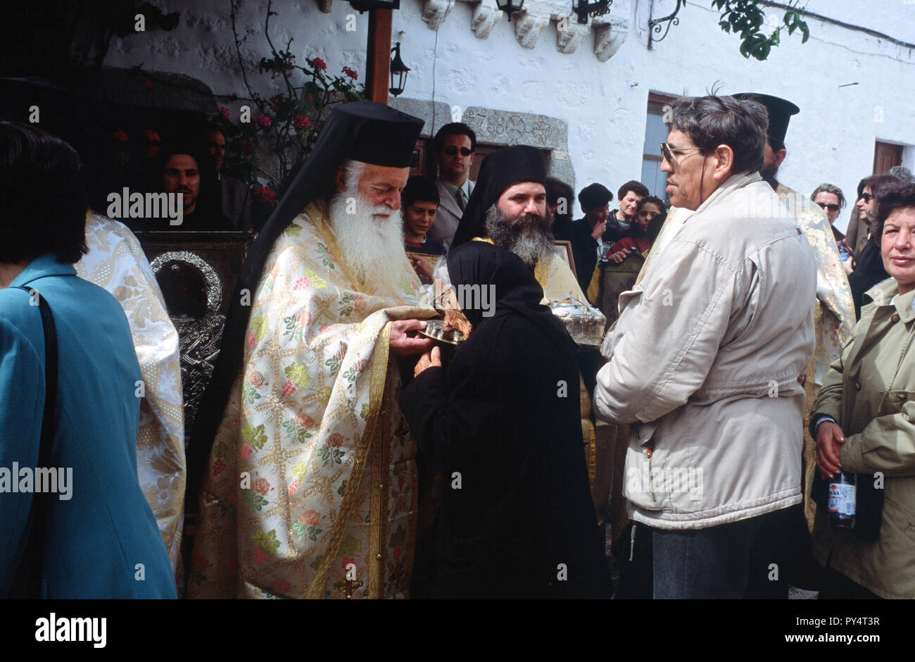 An elderly woman kisses a sacred relic held by a monk during Holy Week celebrations on the Greek island of Patmos. Stock Photo