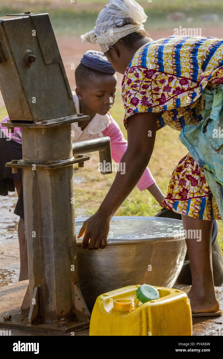 Ghana, Accra January 02, 2017 African Ghana girl with her mum take water at the well in Accra