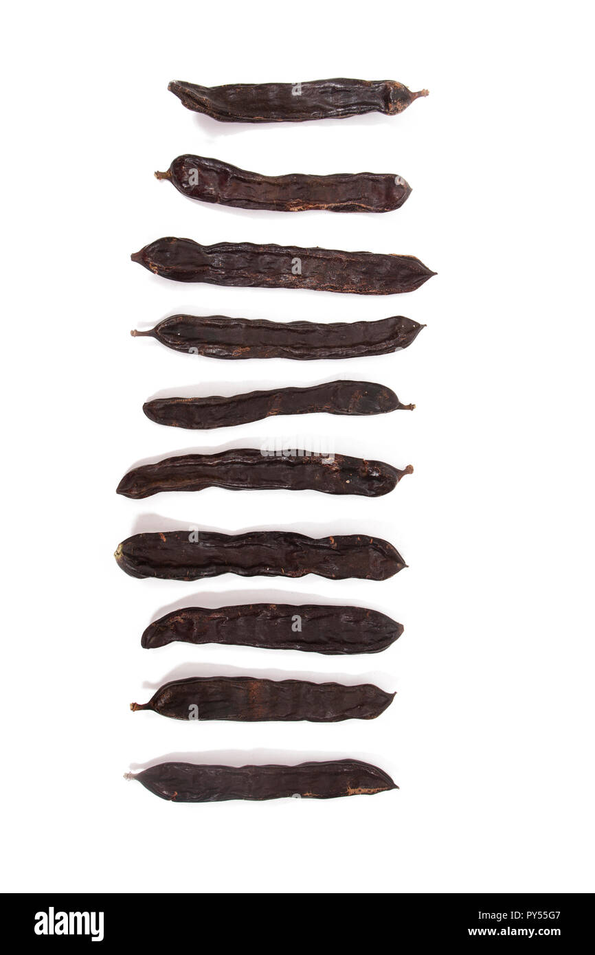 pile of carob fruits isolated over a white background Stock Photo Alamy