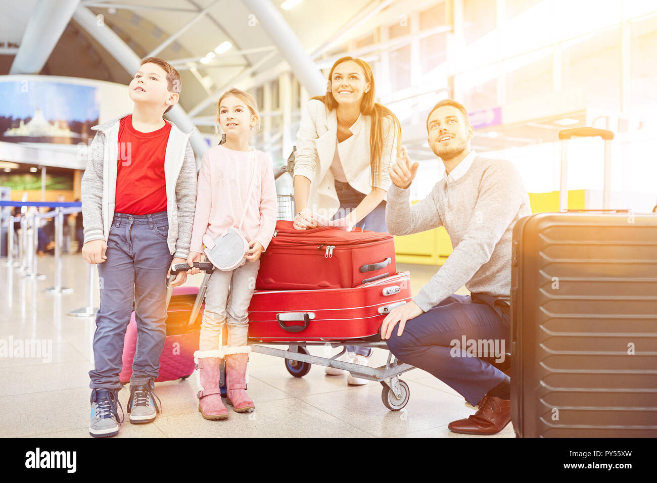 Family with two children and luggage at the airport or train station on vacation Stock Photo