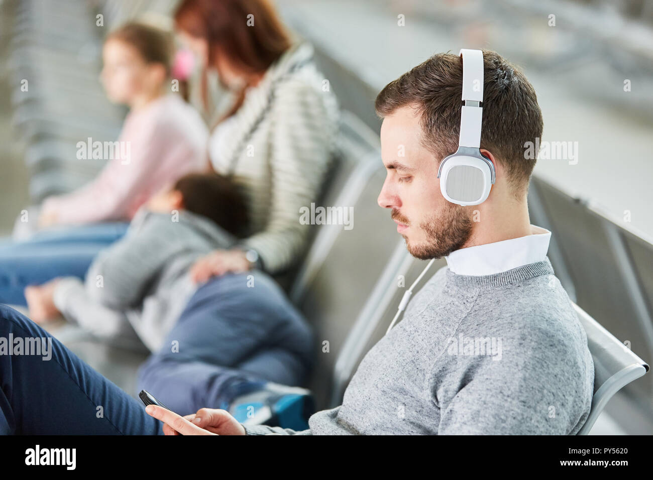 Man with headphones and smartphone listens to music streaming in the