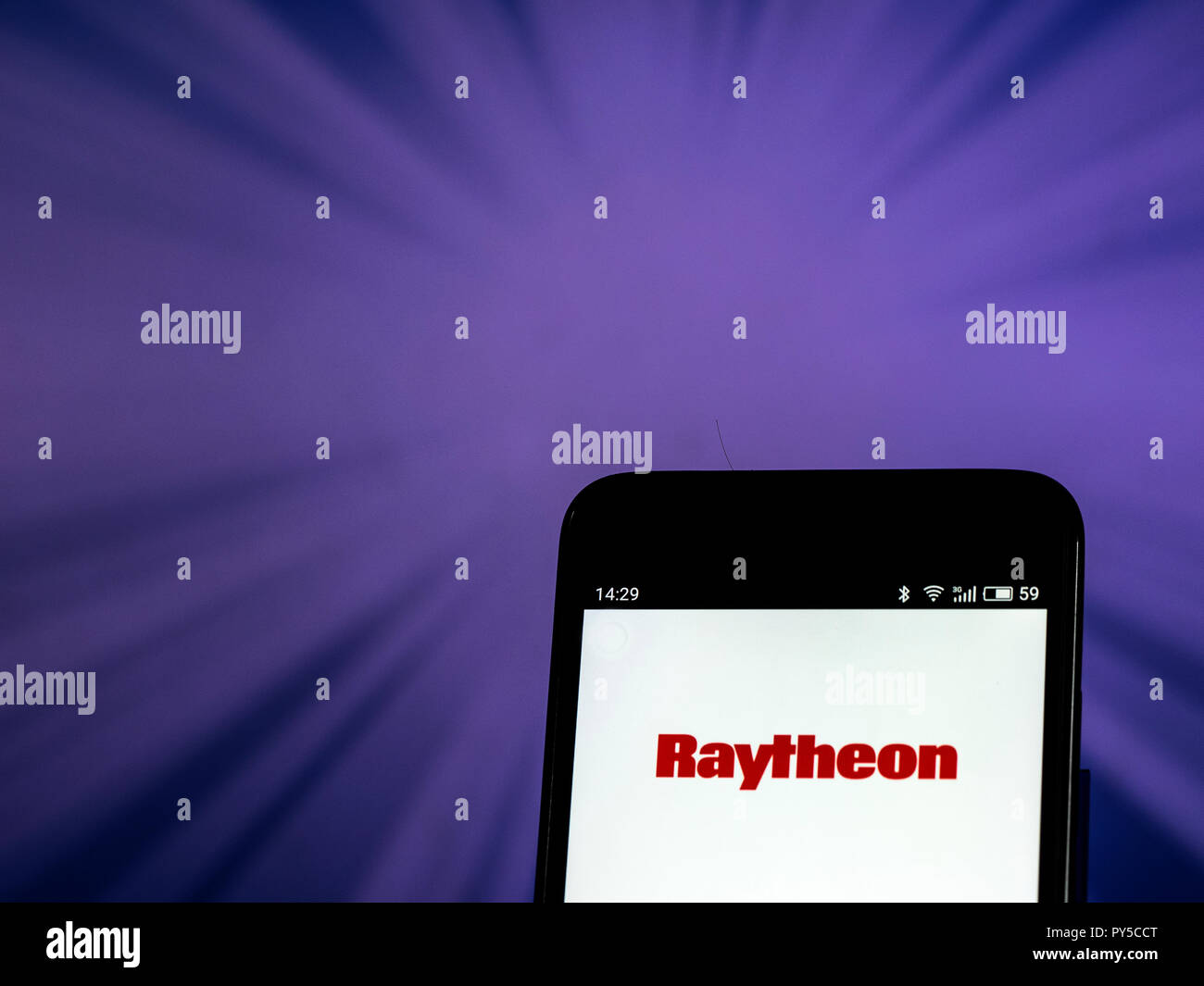 Raytheon Defense contractor company logo seen displayed on smart phone.The Raytheon Company is a major U.S. defense contractor and industrial corporation with core manufacturing concentrations in weapons and military and commercial electronics. Stock Photo