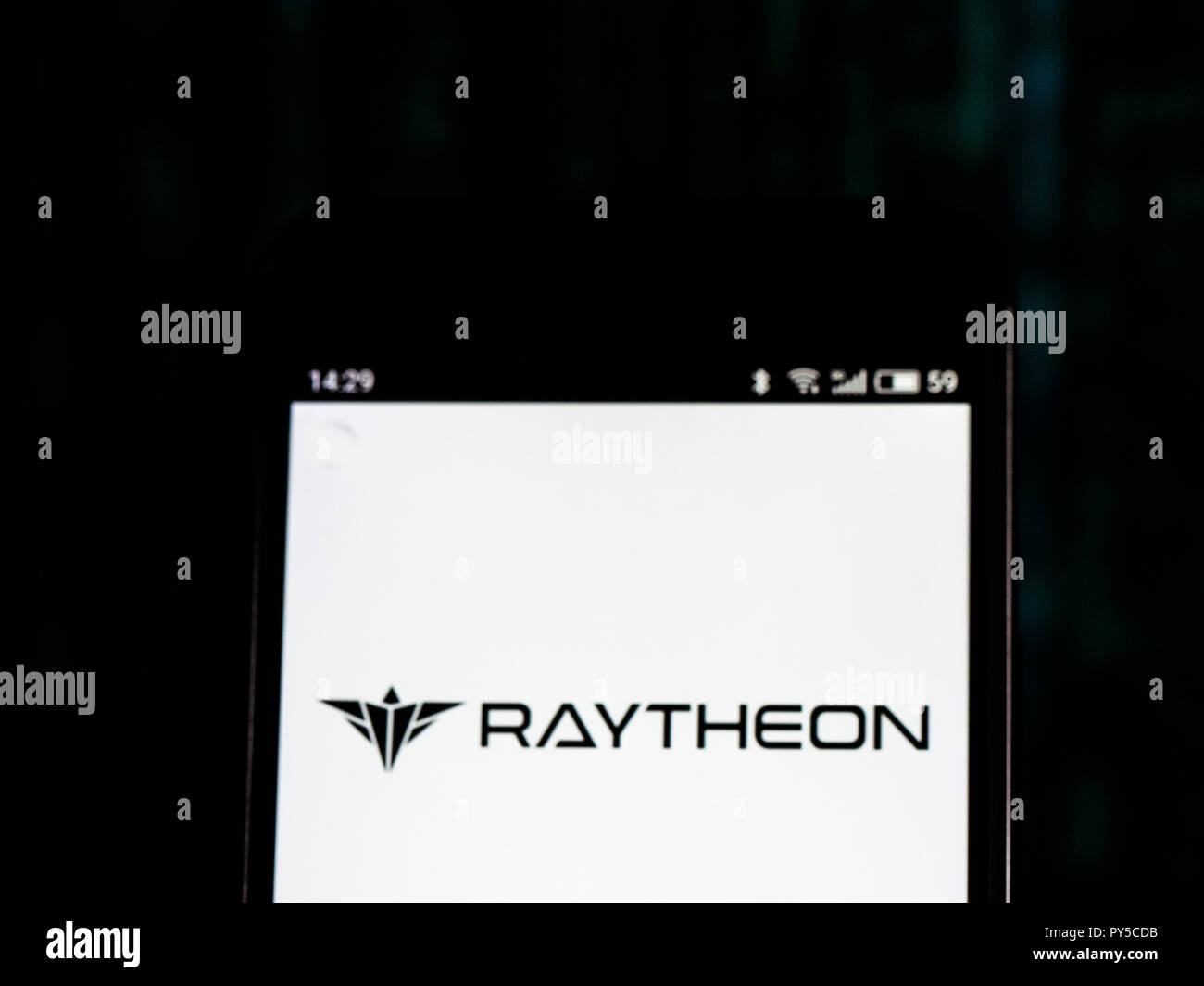 Raytheon Defense contractor company logo seen displayed on smart phone.The Raytheon Company is a major U.S. defense contractor and industrial corporation with core manufacturing concentrations in weapons and military and commercial electronics. Stock Photo