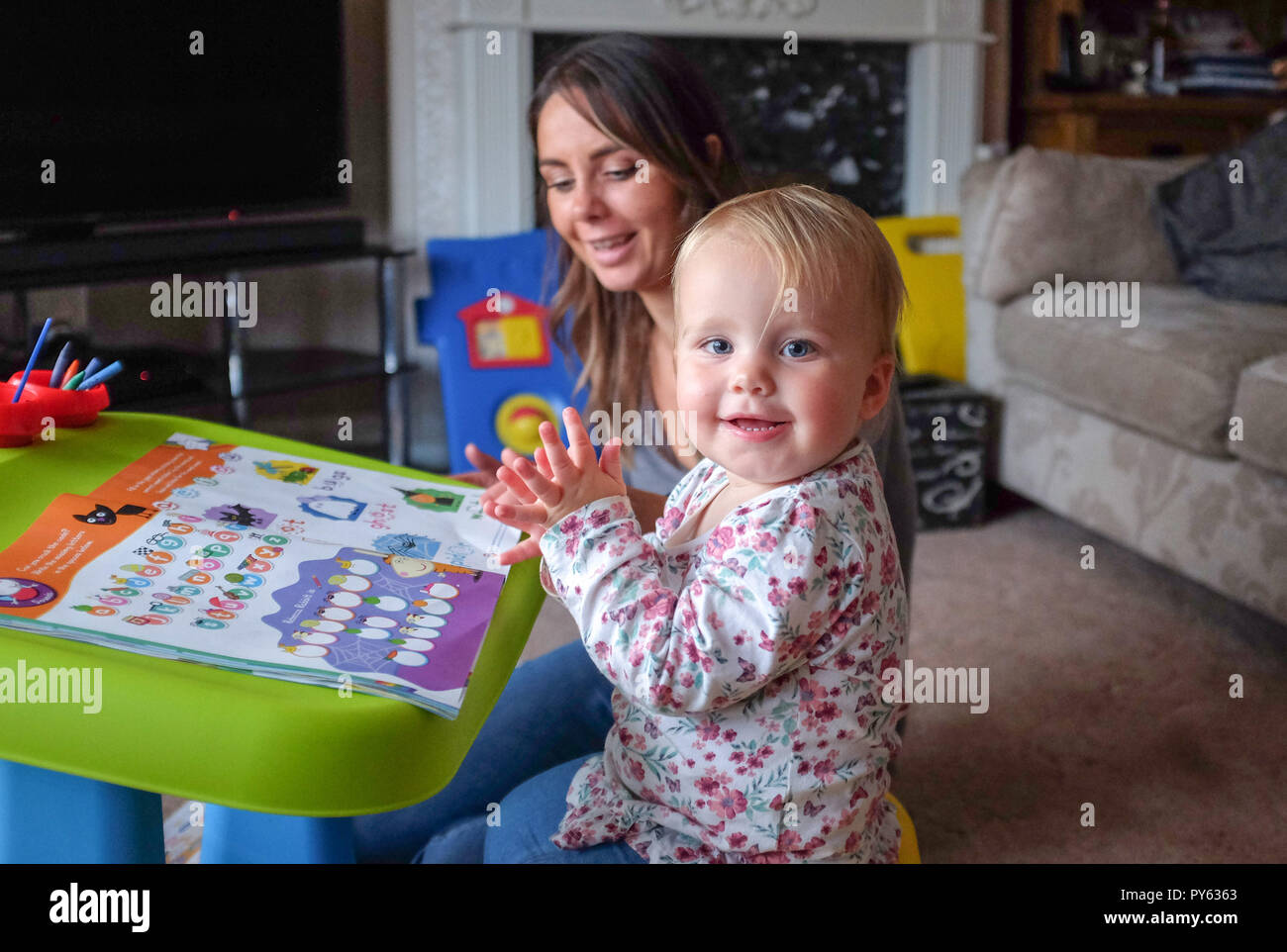 Young two year old baby toddler girl with her mother playing at home