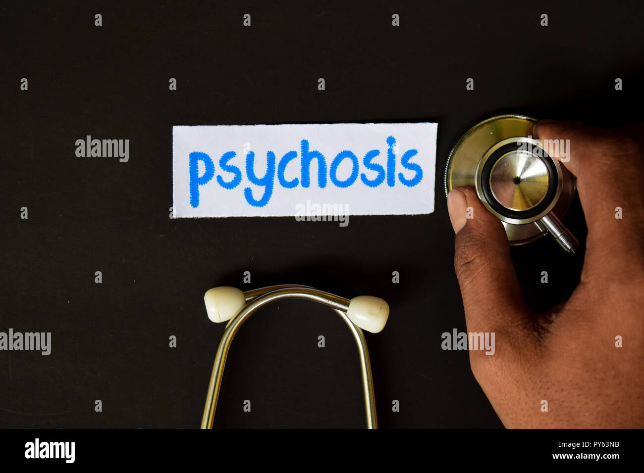 Conceptual image with Psychosis inscription with the view of stethoscope, in someone hand with black background. Medical Conceptual. Stock Photo