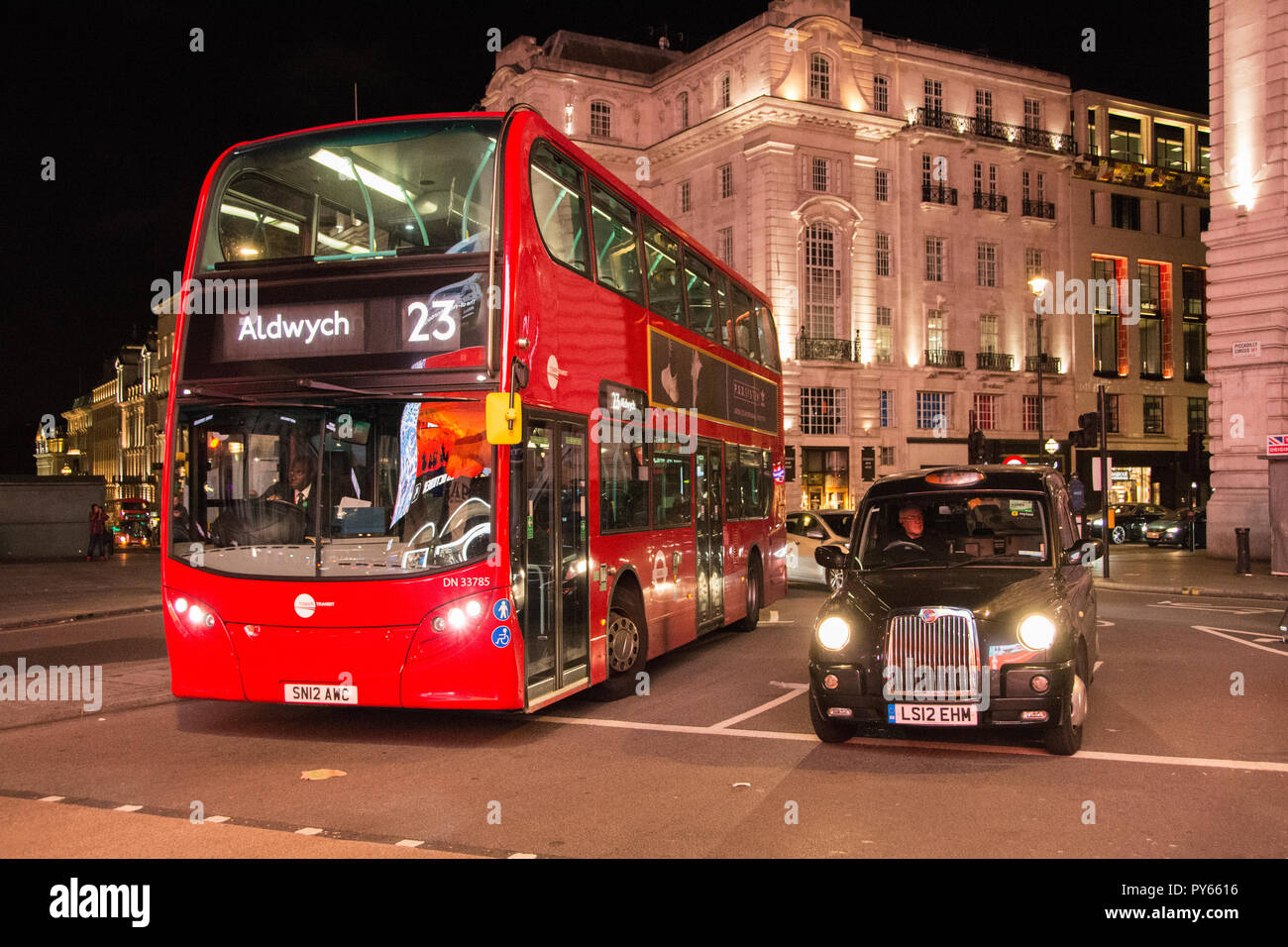 A black London taxi can alongside an Enviro400H MMC double decker London bus at Piccadilly Circus, London, UK Stock Photo