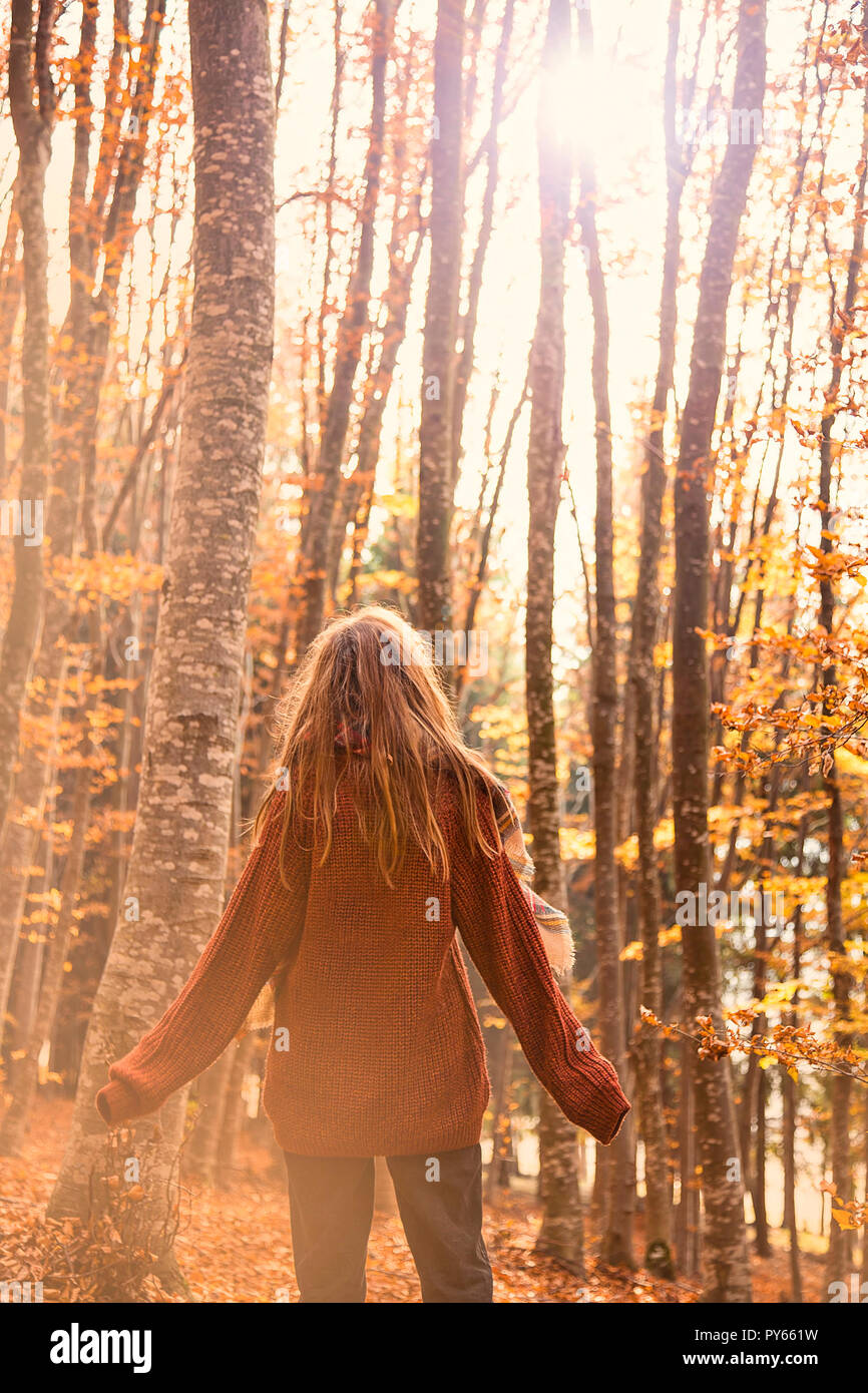 Young girl in autumn season in the park, back shot of a girl with scarf in fall outdoor, dreamy beautiful fall concept Stock Photo