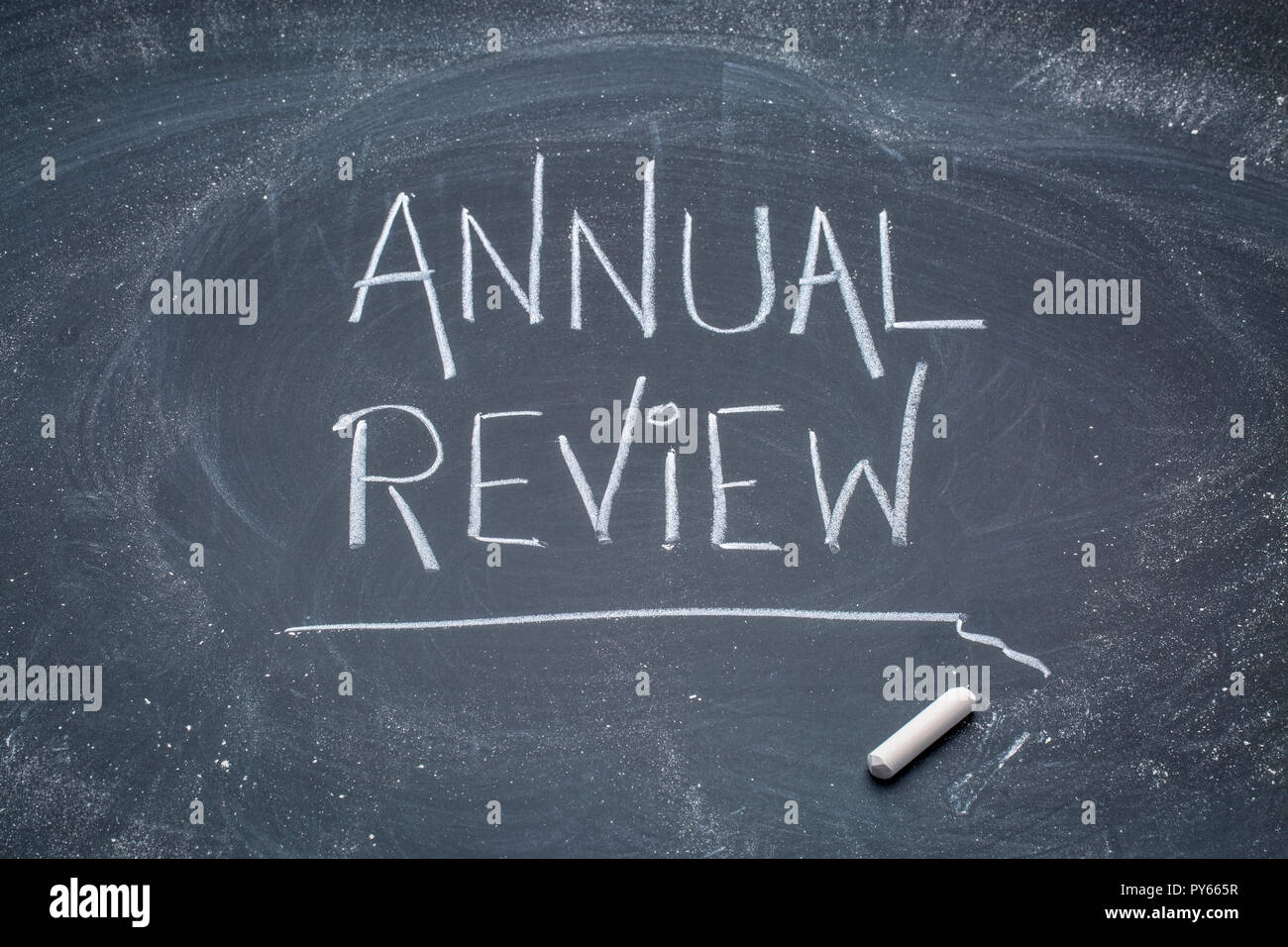 Annual review sign - white chalk messy handwriting on a blackboard Stock Photo