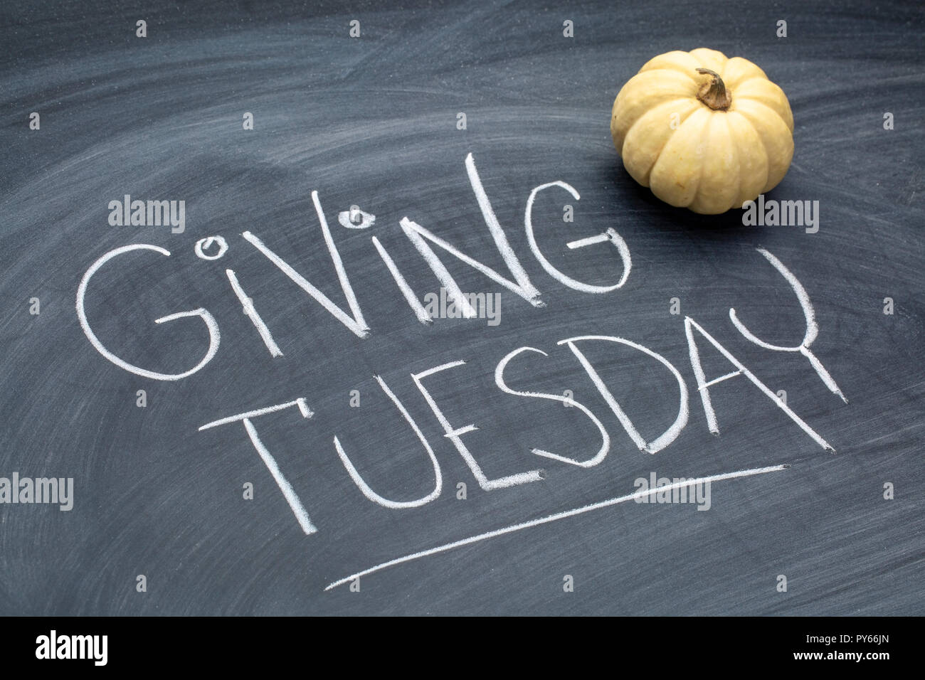 Giving Tuesday  - white chalk handwriting on a  blackboard  with ornamental gourd Stock Photo