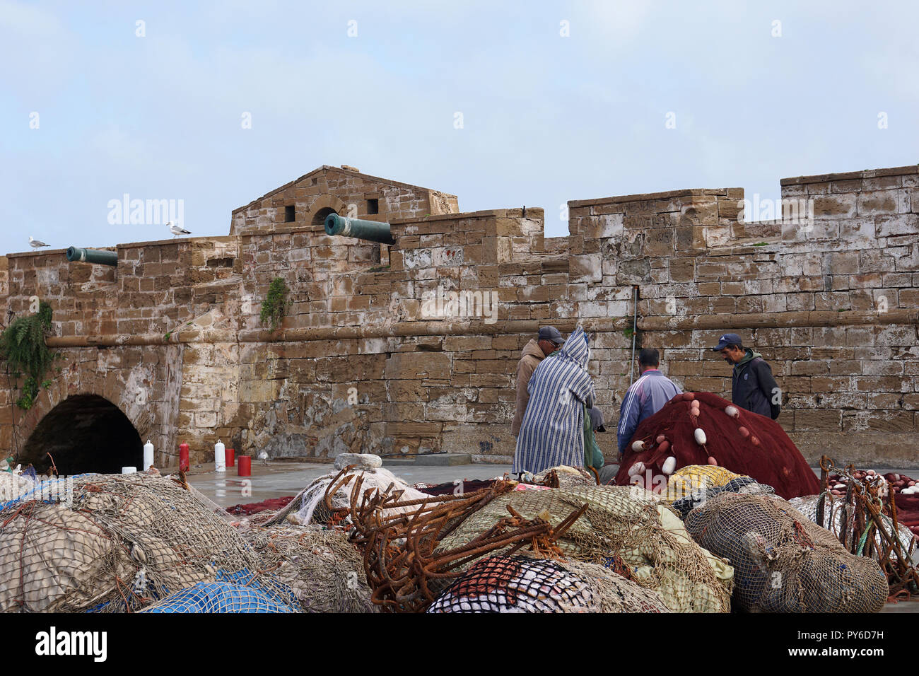 Locals repairing fishing nets in fishing port of Essaouira, Morocco Stock Photo