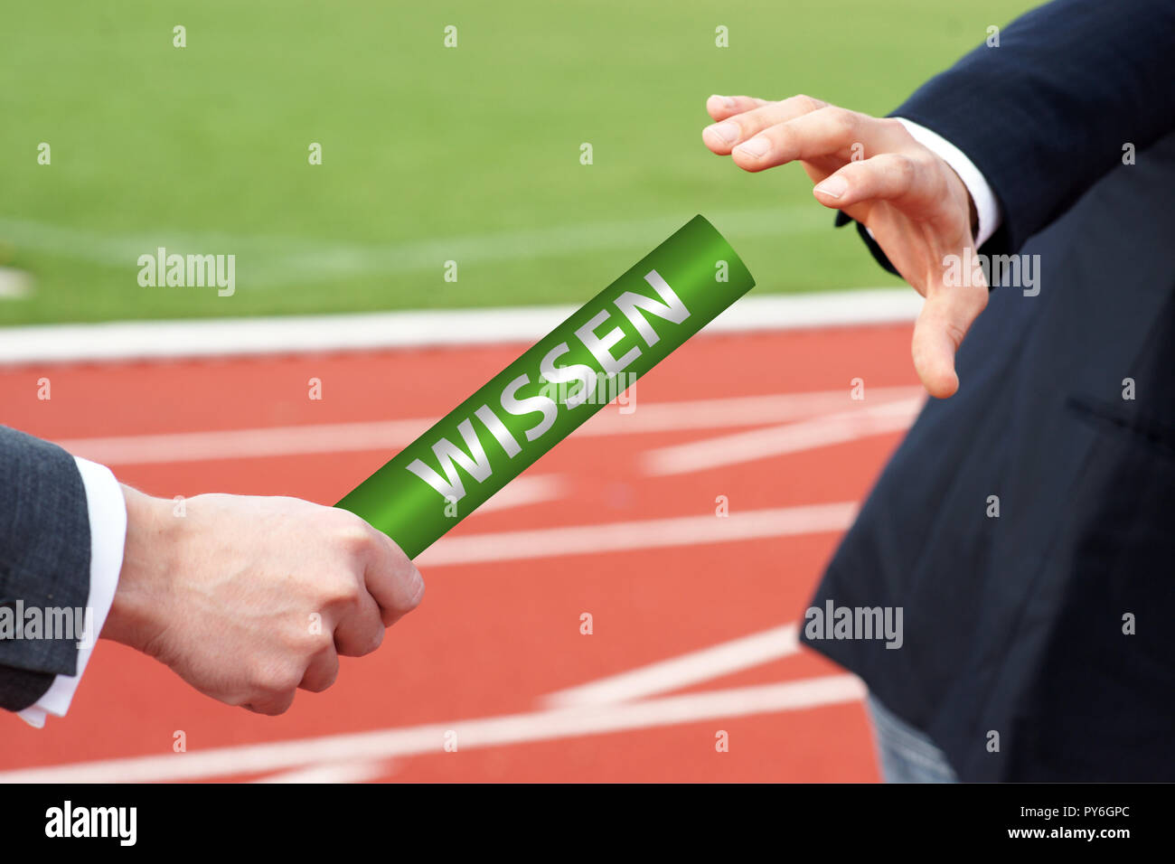 Businessmen passing baton with german word - Wissen Stock Photo