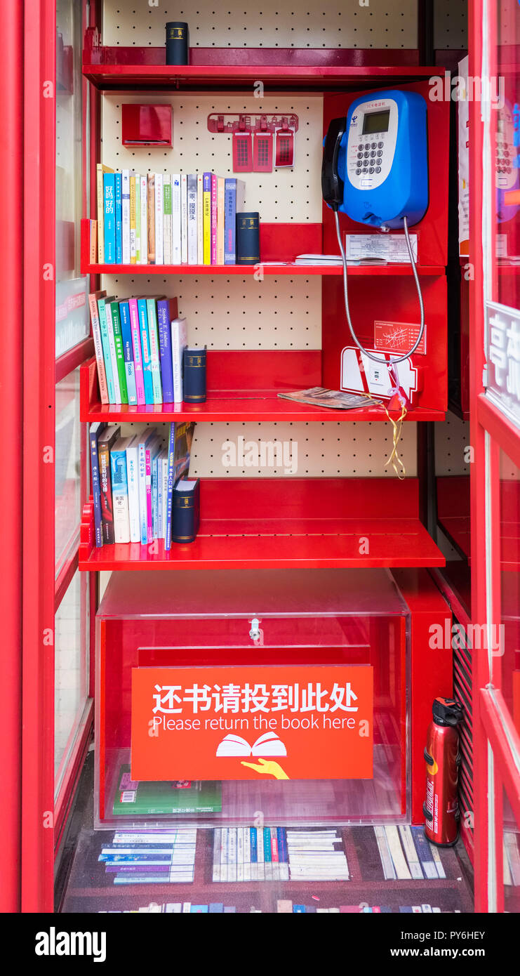 One of the telephone boxes in Shanghai, China, Asia now used both as a book lending library and a wifi hotspot, Stock Photo