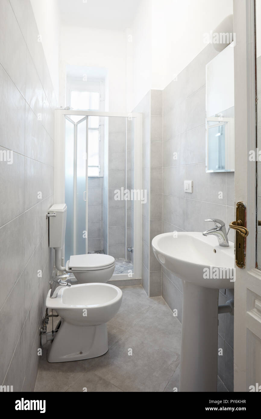 Renovated narrow bathroom with gray cement tiles Stock Photo