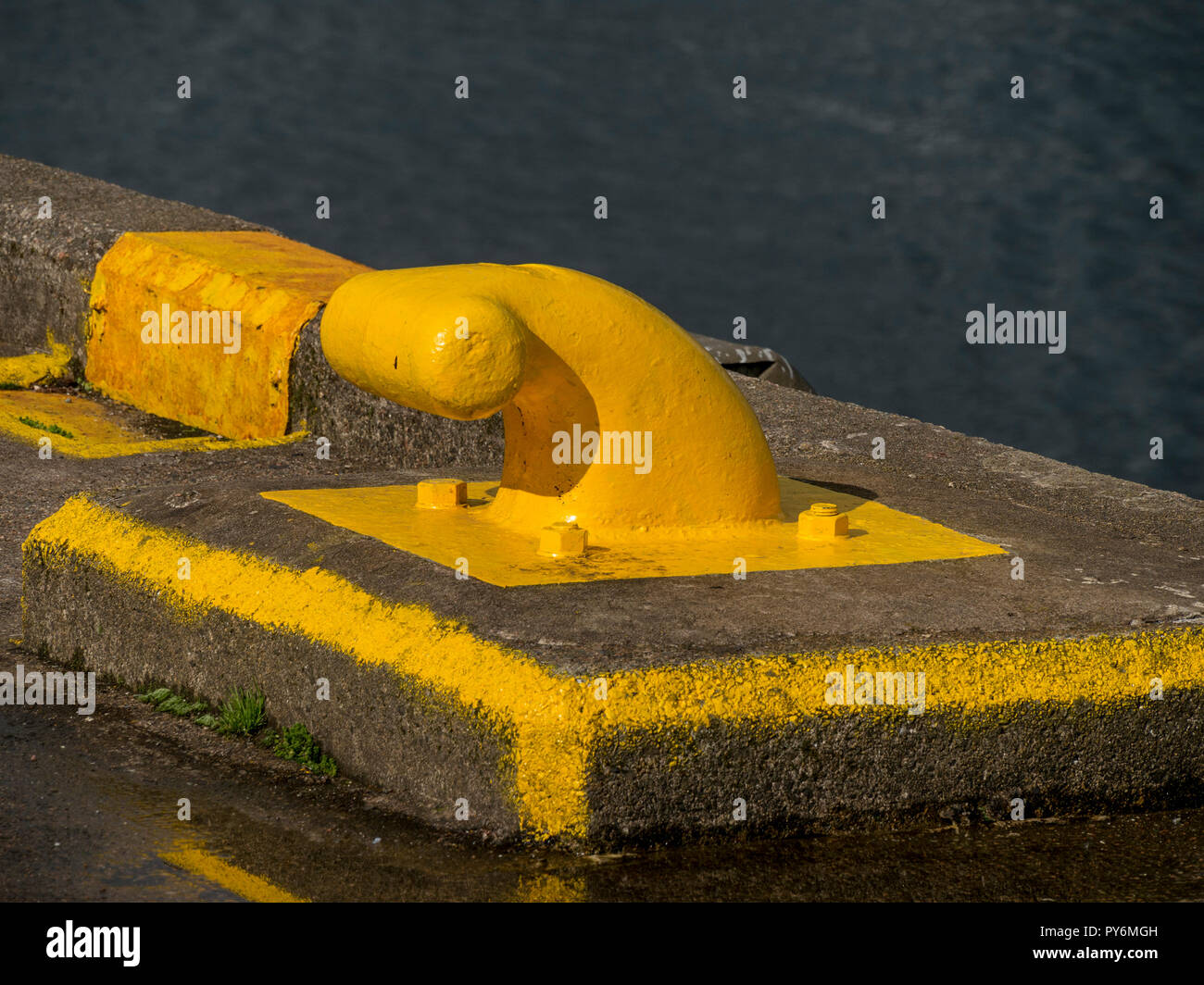 Bright yellow painted ferry mooring bollard at Armadale Ferry Terminal Pier, Isle of Skye, Scotland, UK Stock Photo