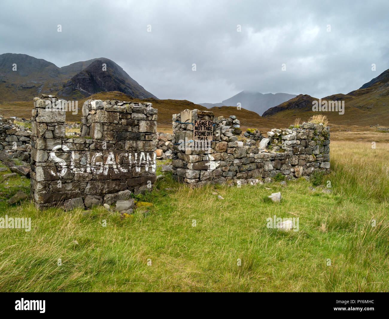 Ruins of old stone building at Camasunary with signs to Sligachan and 'Please do not take stone off this building', Isle of Skye, Scotland, UK. Stock Photo