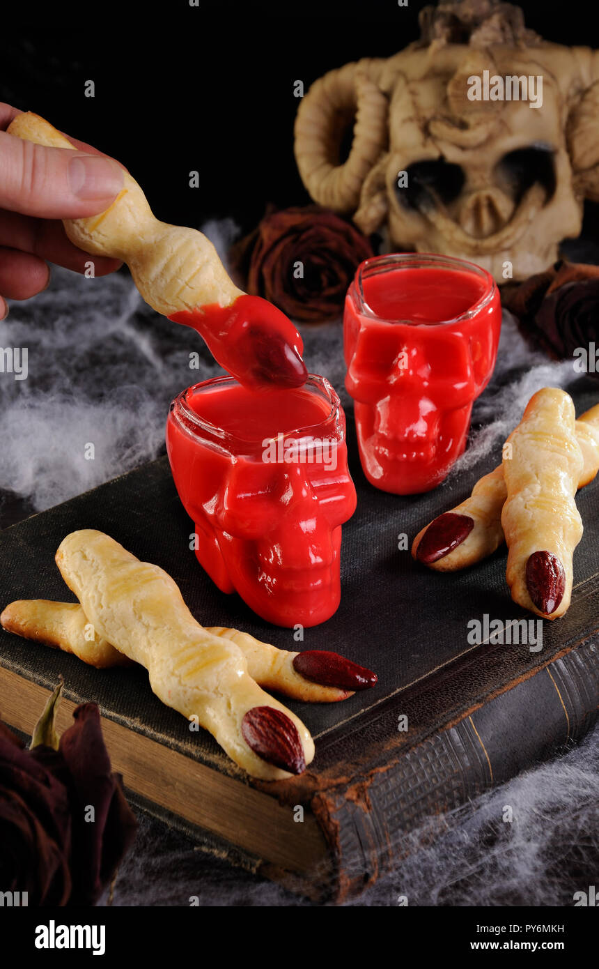 Dip crispy shortbread cookies in the form of witch fingers in hot chocolate 'Red Velvet'.This is just delicious. Stock Photo