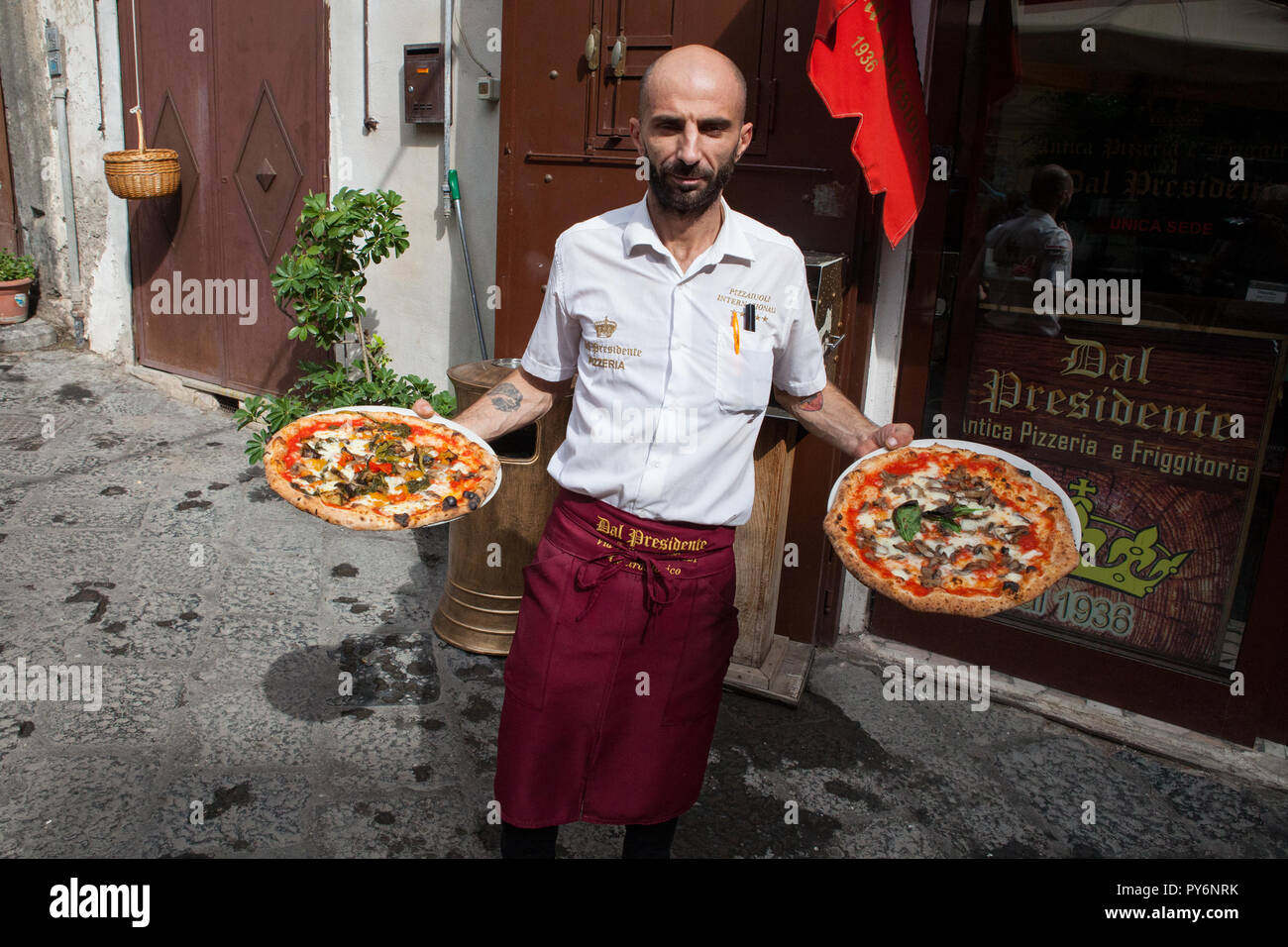 Waiter serving pizzas in Naples, Italy Stock Photo