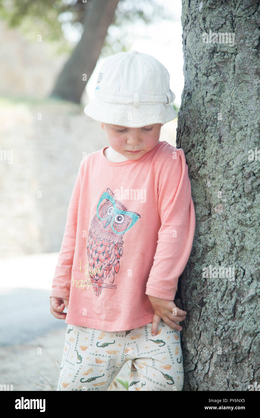 Lovely cute little baby 2-4 years old girl in pink t-shirt and white in hot weather of summer in Croatia holiday. Stock Photo