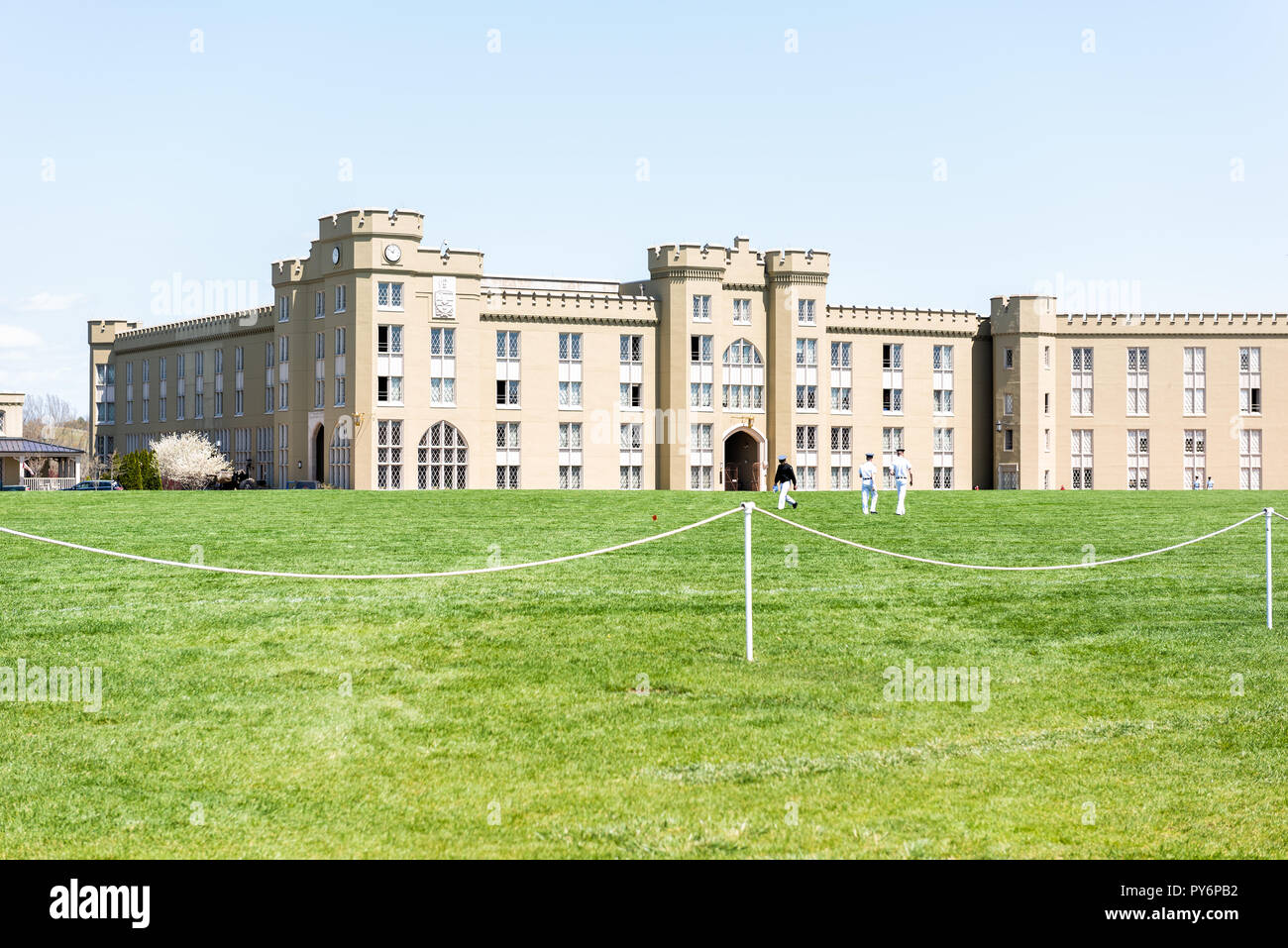 Lexington, USA - April 18, 2018: Virginia Military Institute cadets in uniform walking on green grass lawn during sunny day in front of Clayton Hall Stock Photo
