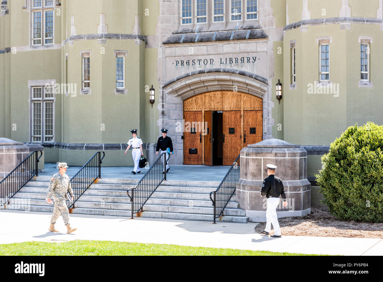 Lexington, USA - April 18, 2018: Virginia Military Institute cadets in uniform walking on green grass lawn during sunny day in front of Preston Librar Stock Photo