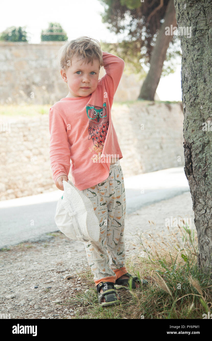 Lovely cute little baby 2-4 years old girl in pink t-shirt and white in hot weather of summer in Croatia holiday. Stock Photo