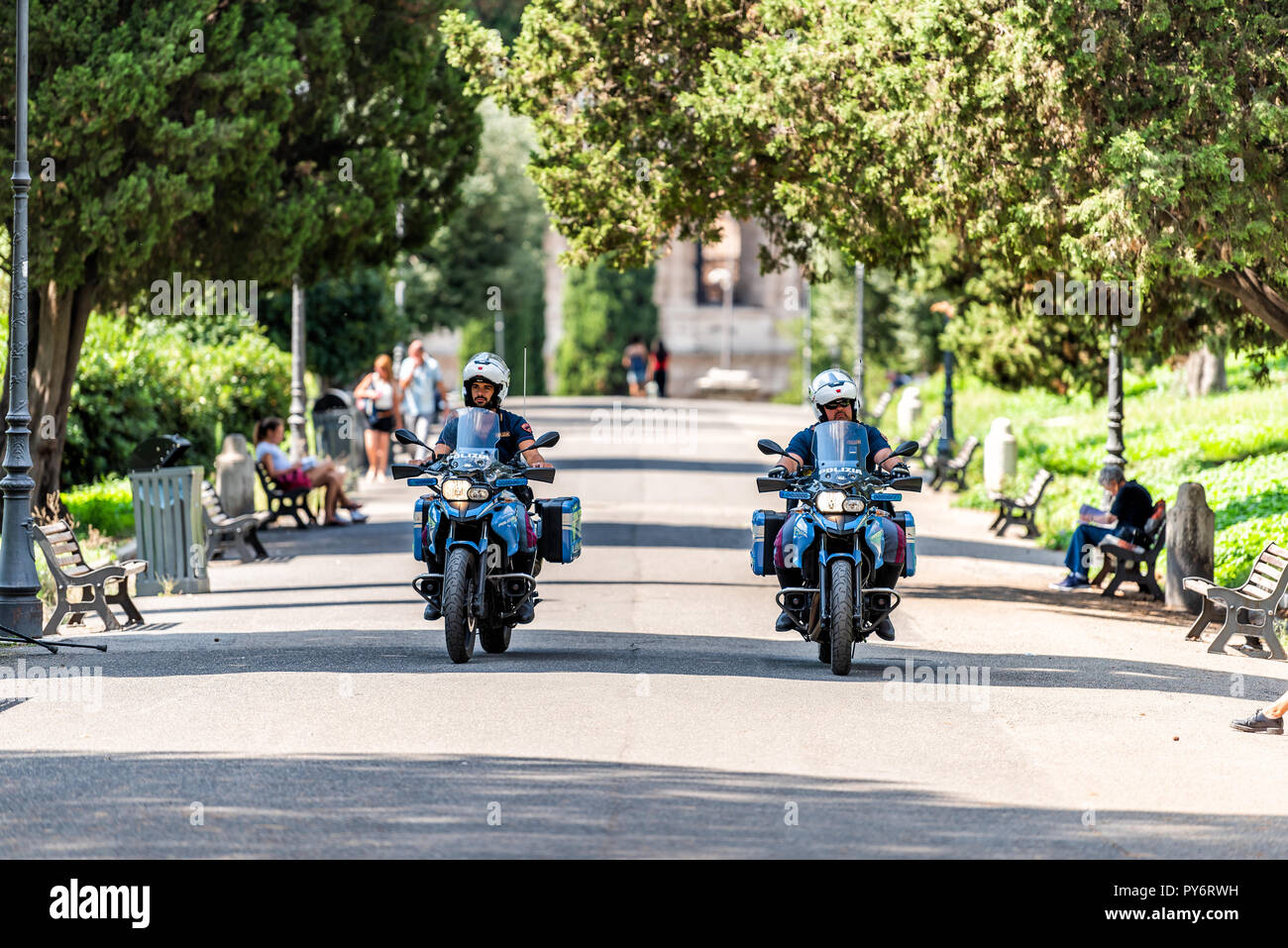 Rome, Italy - September 4, 2018: Historic green city park on Via della Domus Aurea street with security police officers on motorcycles emergency drivi Stock Photo