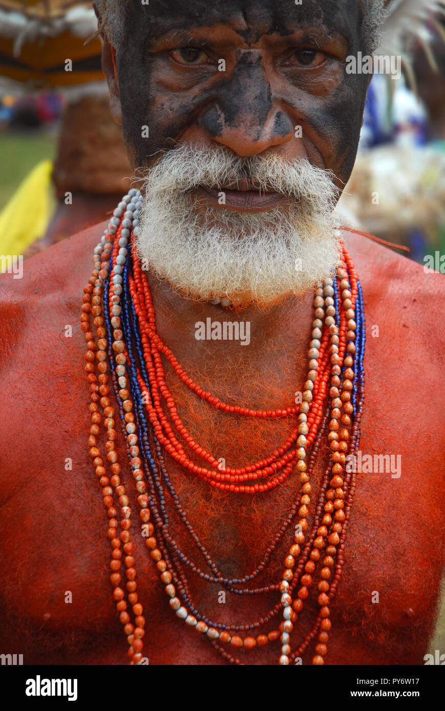 Colourfully dressed and face painted old man with shell necklaces as part of the annual Sing Sing in Madang, Papua New Guinea. Stock Photo