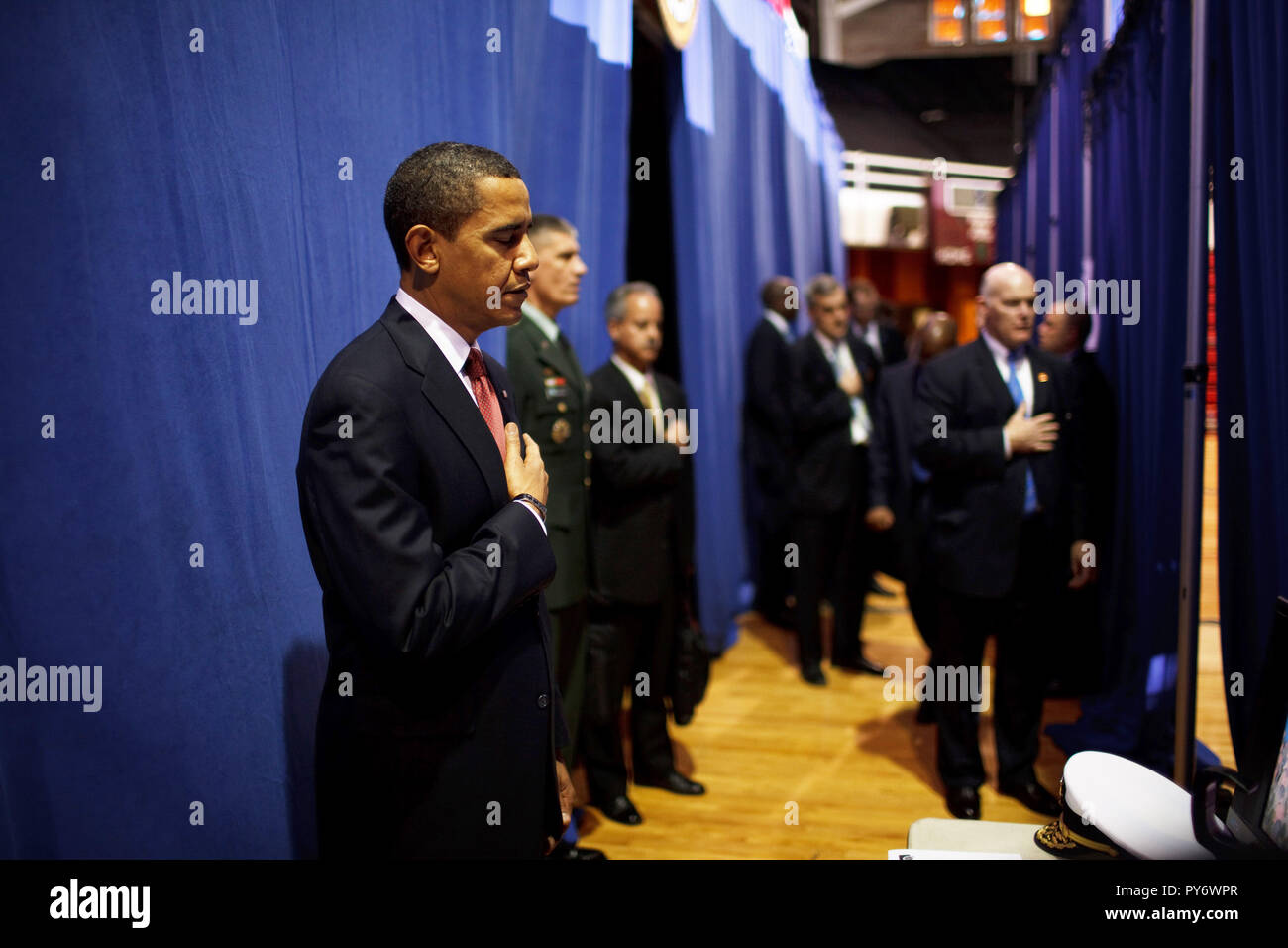 Before giving a policy speech on Iraq, President Barack Obama places his hand on his heart as the national anthem is played backstage  at the Field House, Camp Lejeune, North Carolina 2/27/09.  Official White House Photo by Pete Souza Stock Photo