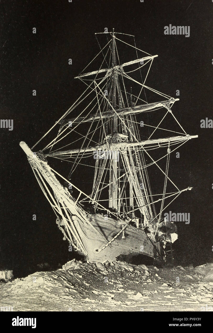 A Specter ship looming stark and white against the darkness of the polar night. THe HMS Endurance during the Shackleton Expedition Stock Photo