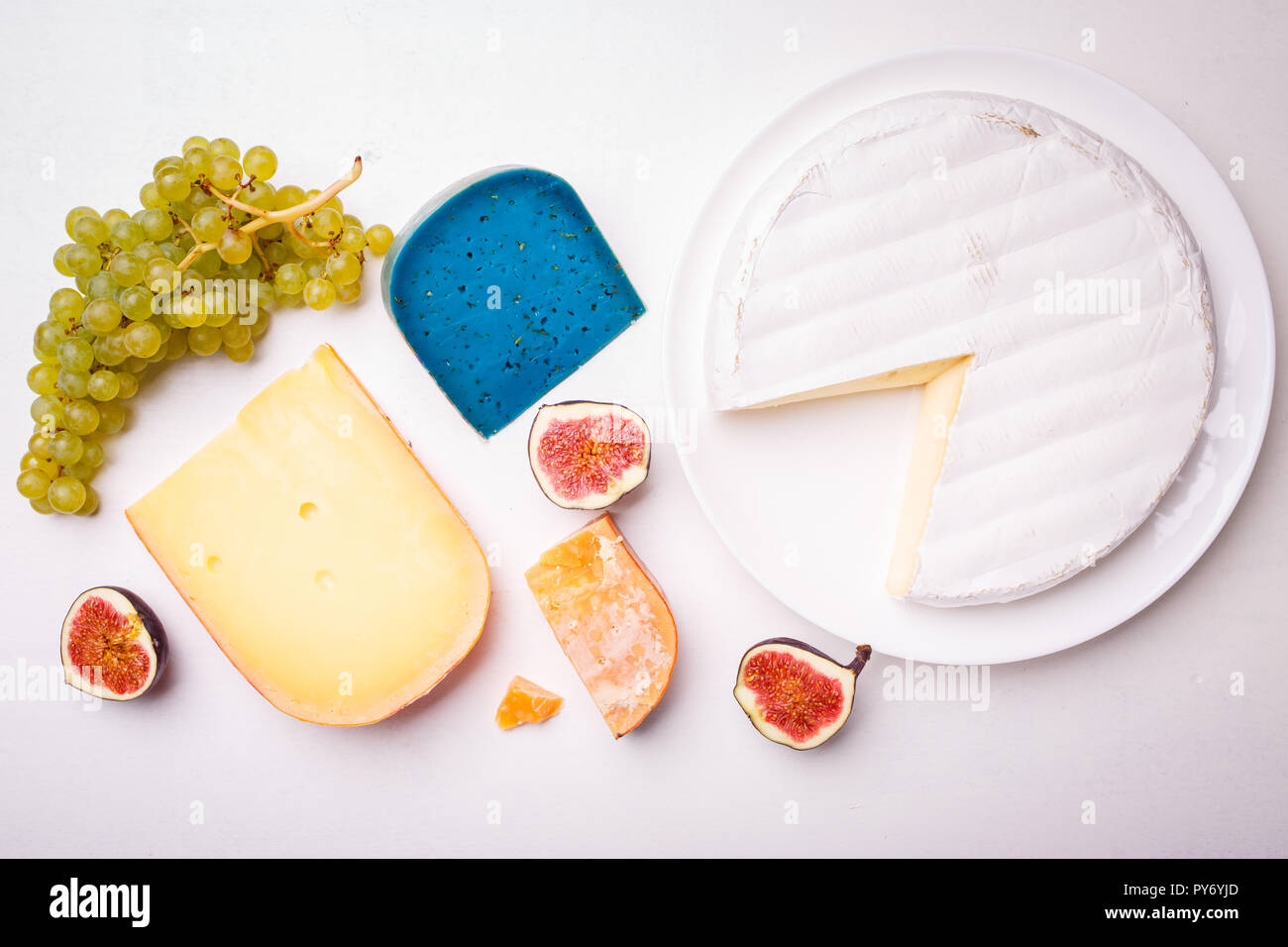 Variety of different cheese with nuts and grapes on the table. Top view image of soft and hard cheeses Stock Photo