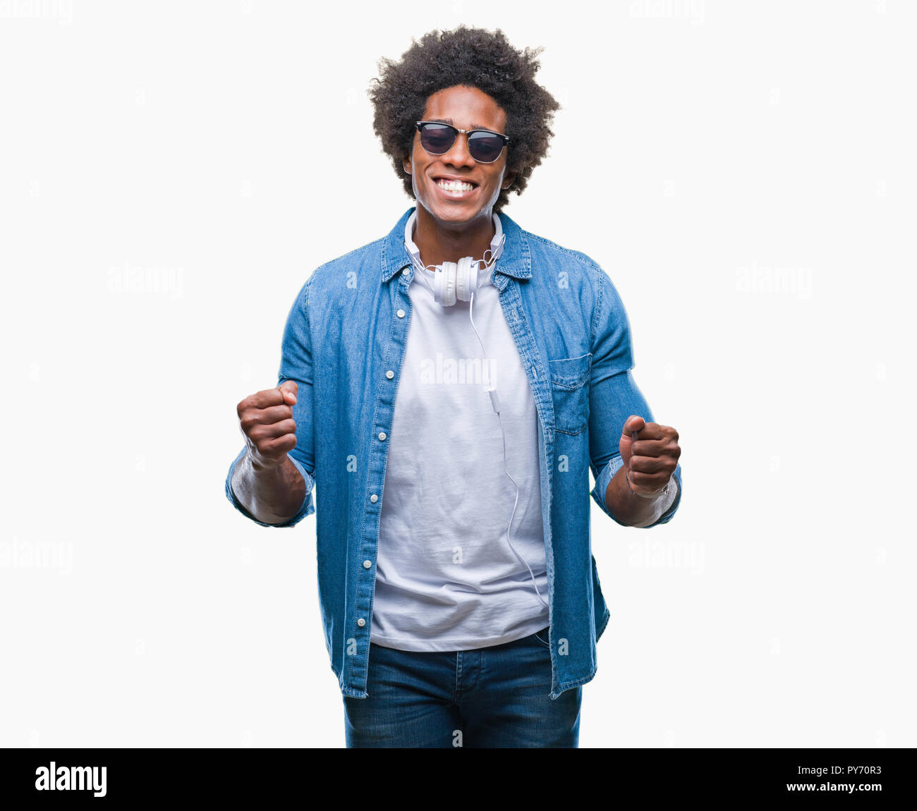 Afro american man wearing headphones listening to music over isolated background very happy and excited doing winner gesture with arms raised, smiling Stock Photo
