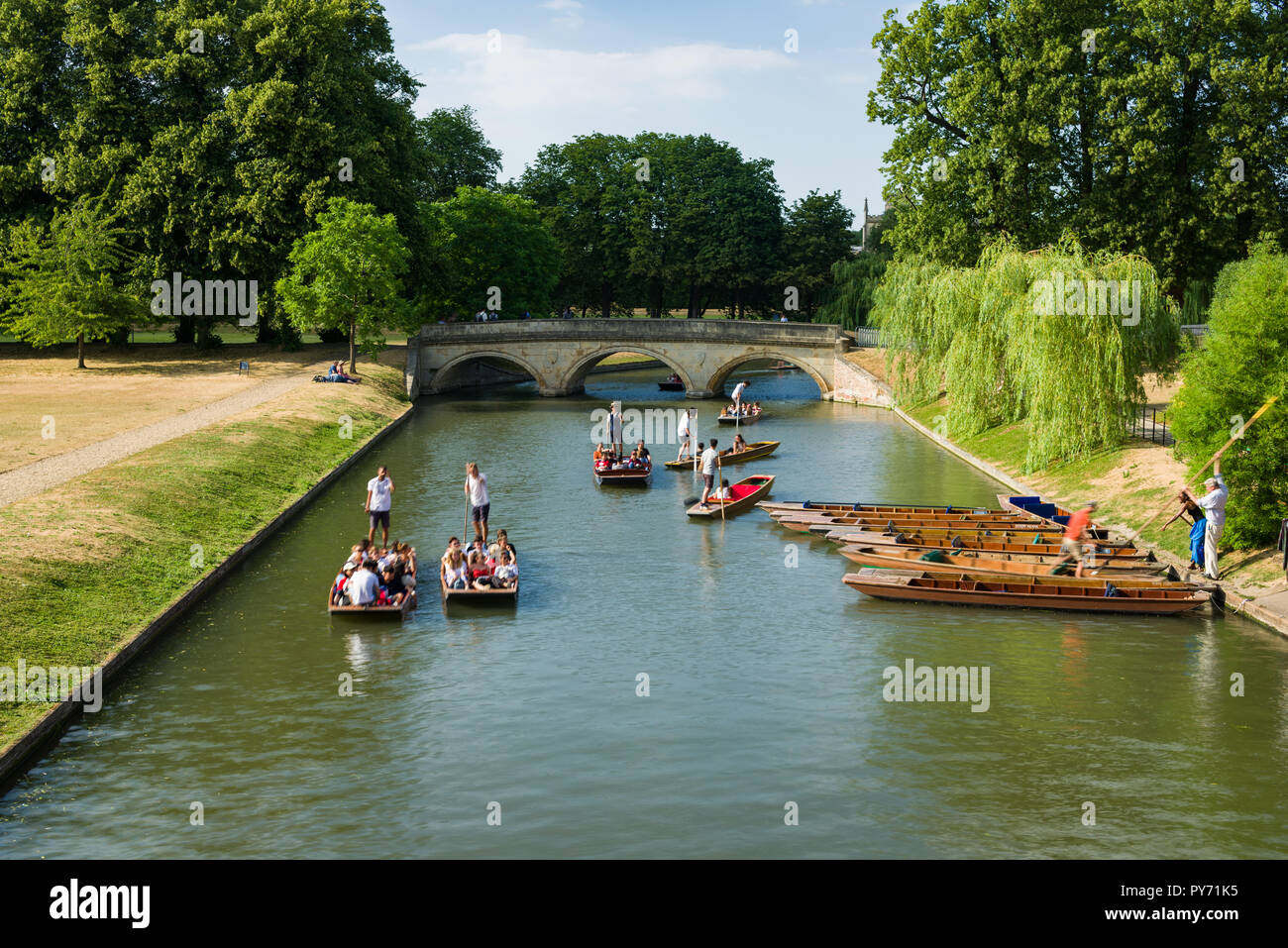 People enjoying punt boat rides along a stretch of the river Cam on a sunny Summer afternoon, Cambridge, UK Stock Photo