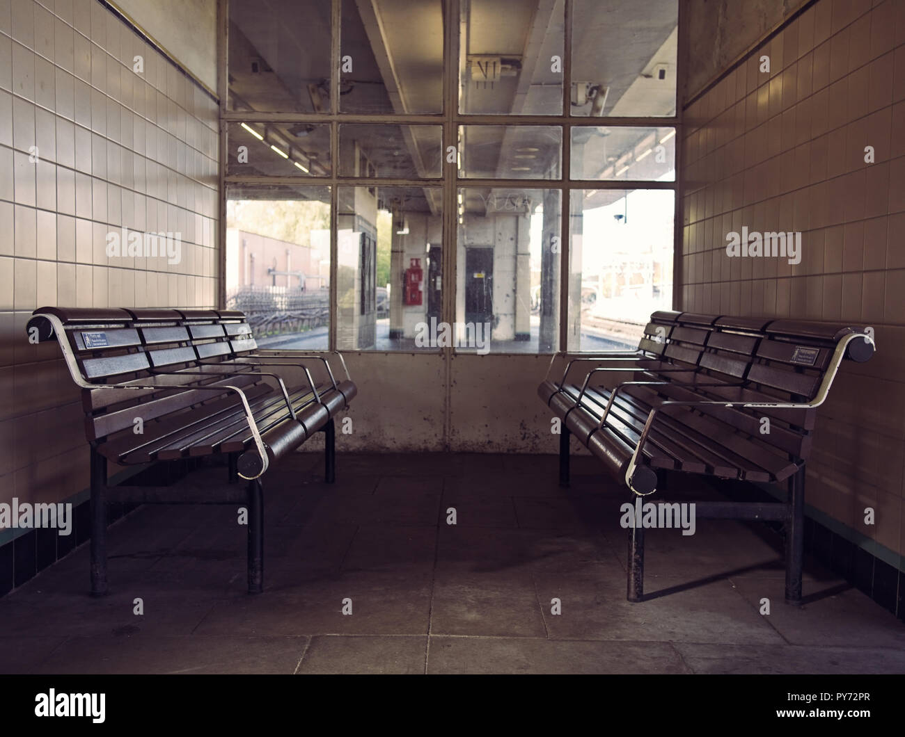 Retro waiting room with wooden benches at a train station Stock Photo