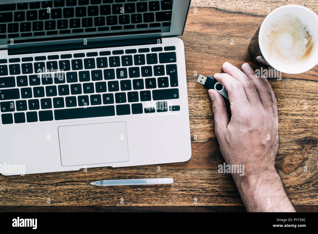 man connecting USB thumb drive to laptop computer Stock Photo