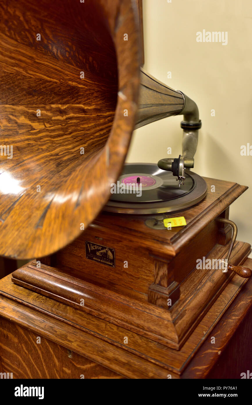 Antique hand cranked Victor phonograph with its wooden horn and mechanical recording reproduction diaphragm with needle on a record, about 1910s Stock Photo