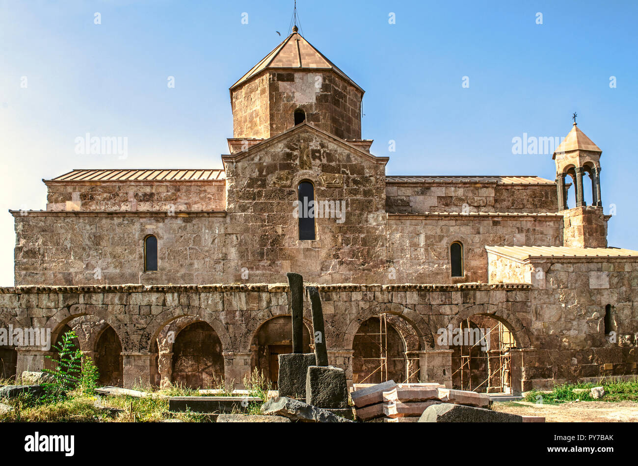 The southern side of Odzun monastery with arched gallery and a medieval cemetery at sunset Stock Photo